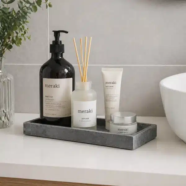 Bandeja de baño de pizarra gris con accesorios decorativos sobre encimera en baño moderno