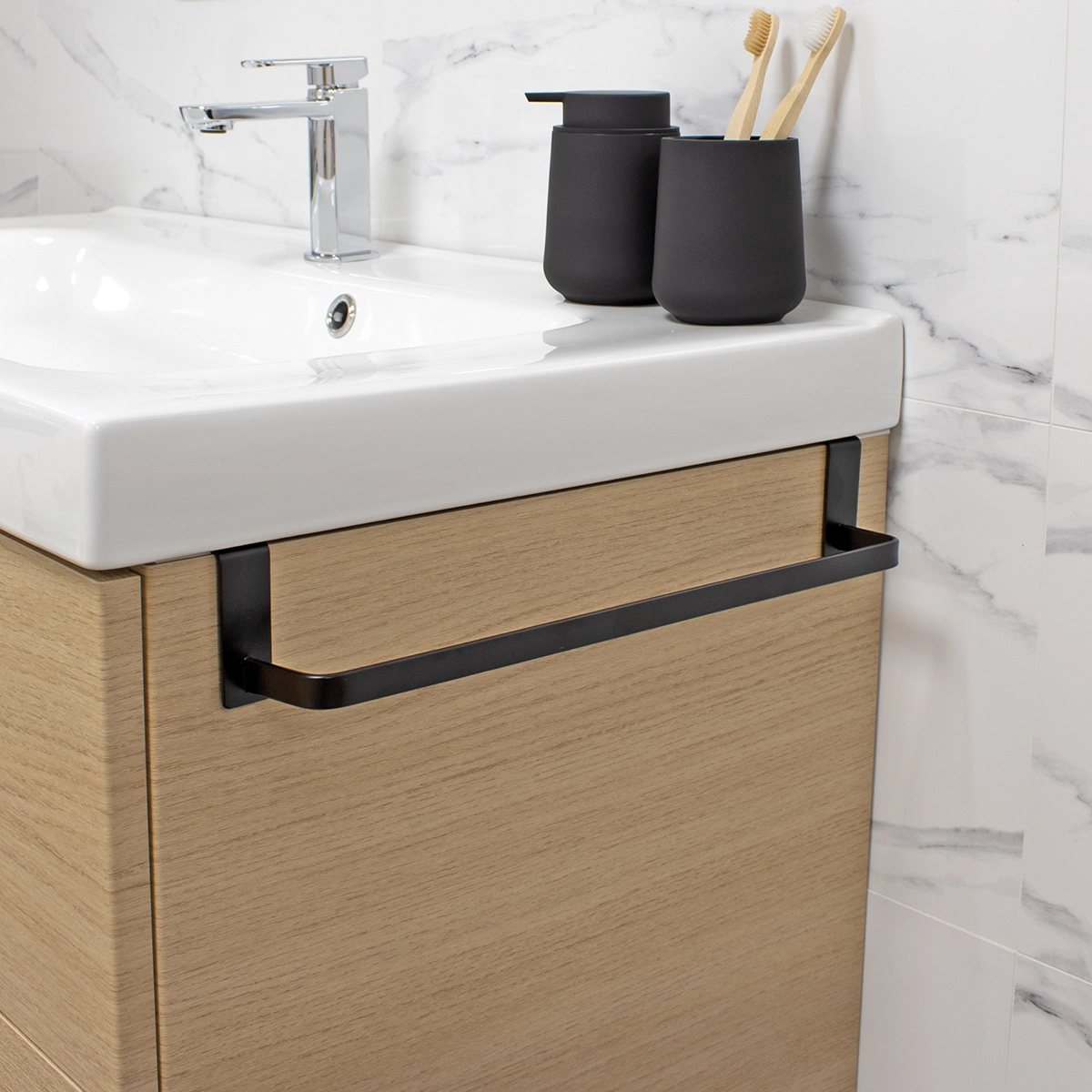 Toallero de acero inoxidable negro mate instalado en mueble de baño de madera clara