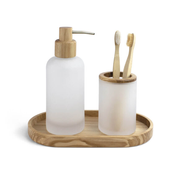 Dispensador de jabón y vaso para cepillos de cristal mate y madera sobre bandeja de baño