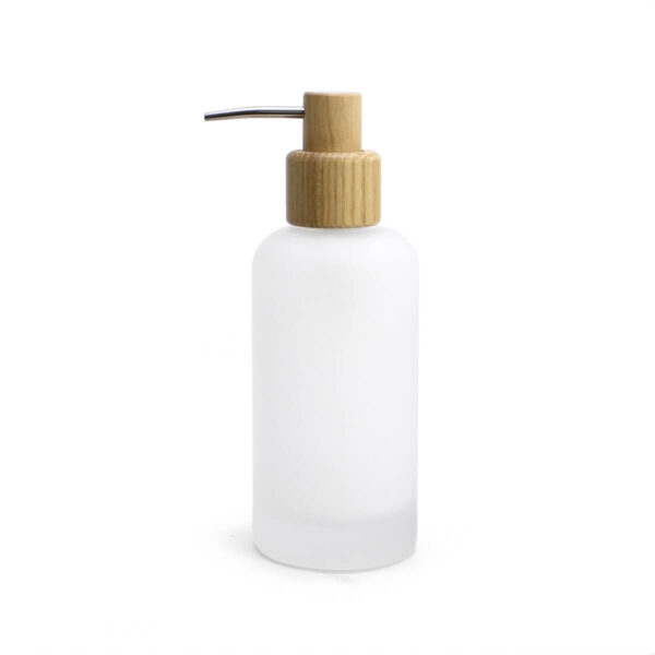 Dispensador de jabón para baño de cristal mate con válvula de madera sobre fondo blanco